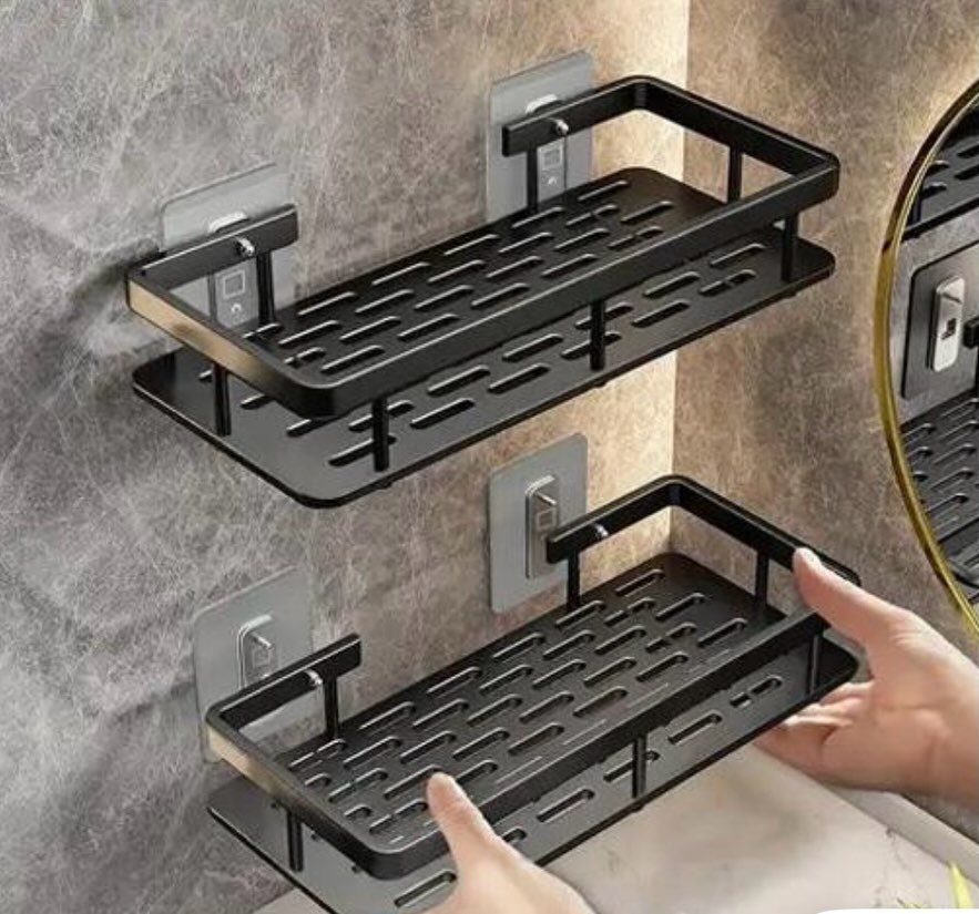 Black metal slatted bathroom shelves mounted on a grey marbled wall.