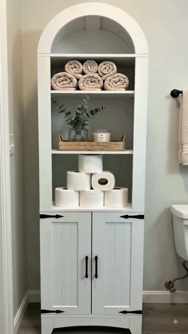 White arched freestanding bathroom storage unit with open shelves and a bottom cabinet.