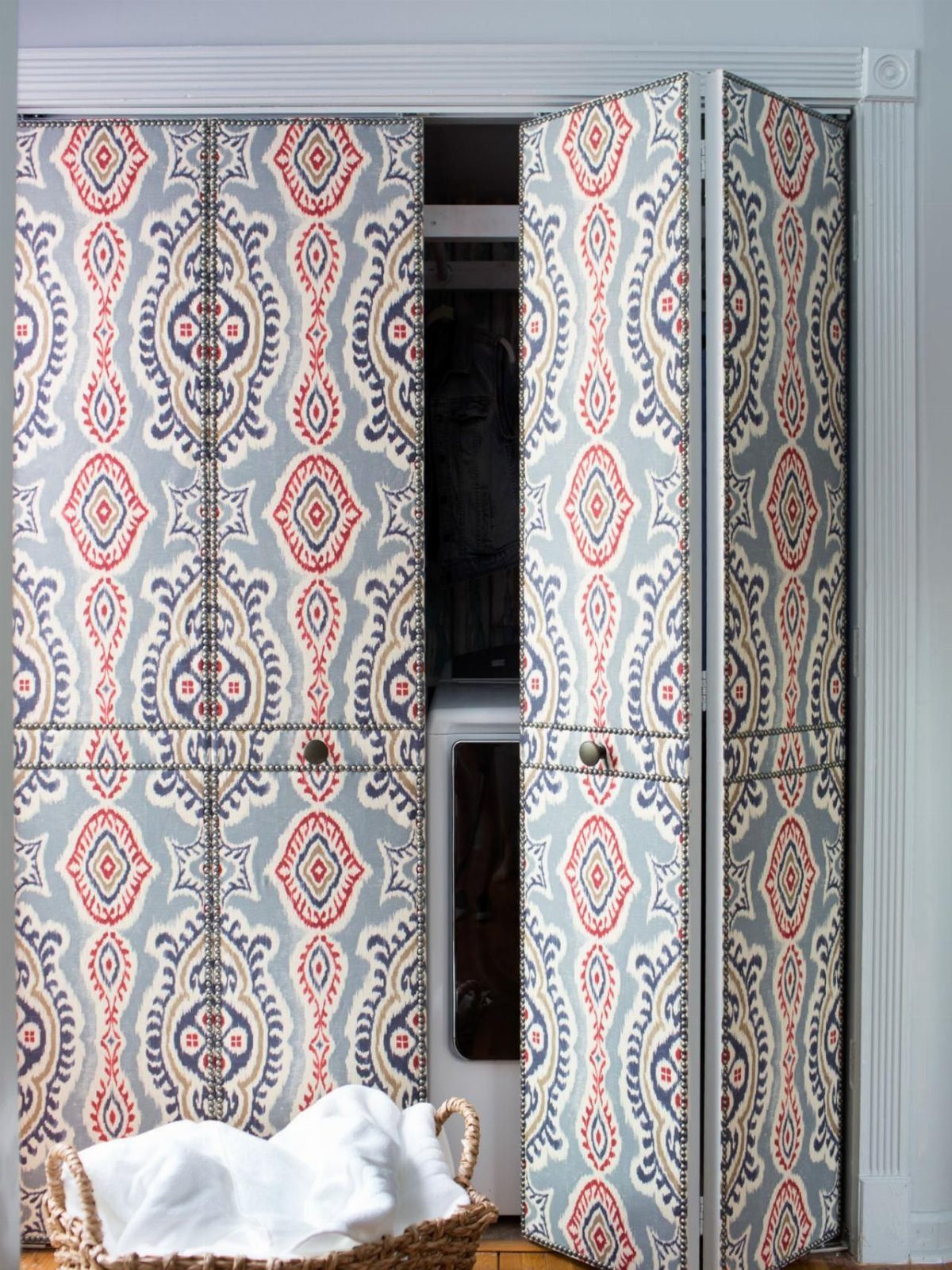 Upholstered bifold closet doors with a blue and red ornate fabric pattern.