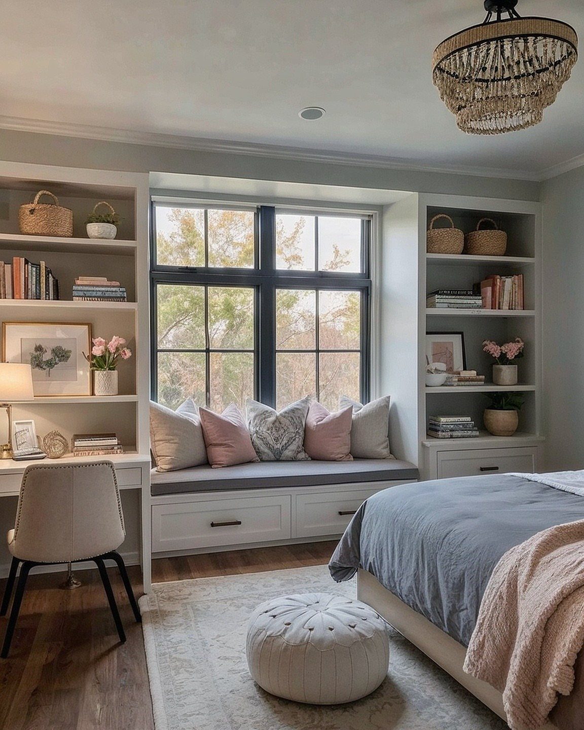 Window seat with pink pillows and built-in shelving in a bright bedroom