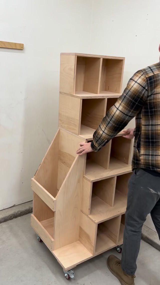 Mobile plywood storage unit with cubbies and a slanted bin for scrap wood.