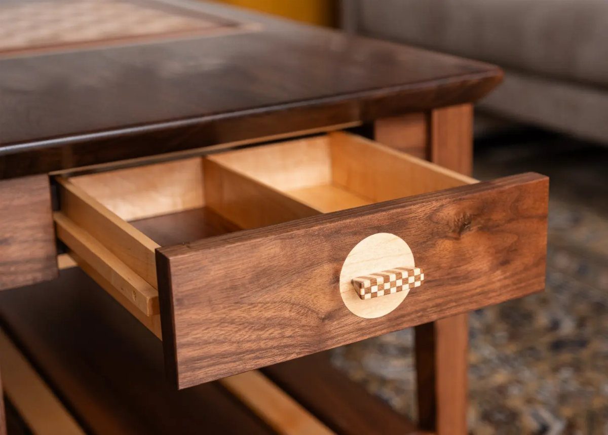 Dark wood chess table with an open drawer and checkered handle in living room