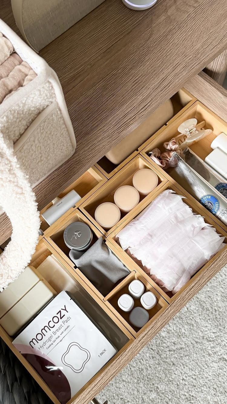 Wooden drawer with built-in organizers holding skincare products and nursing pads.