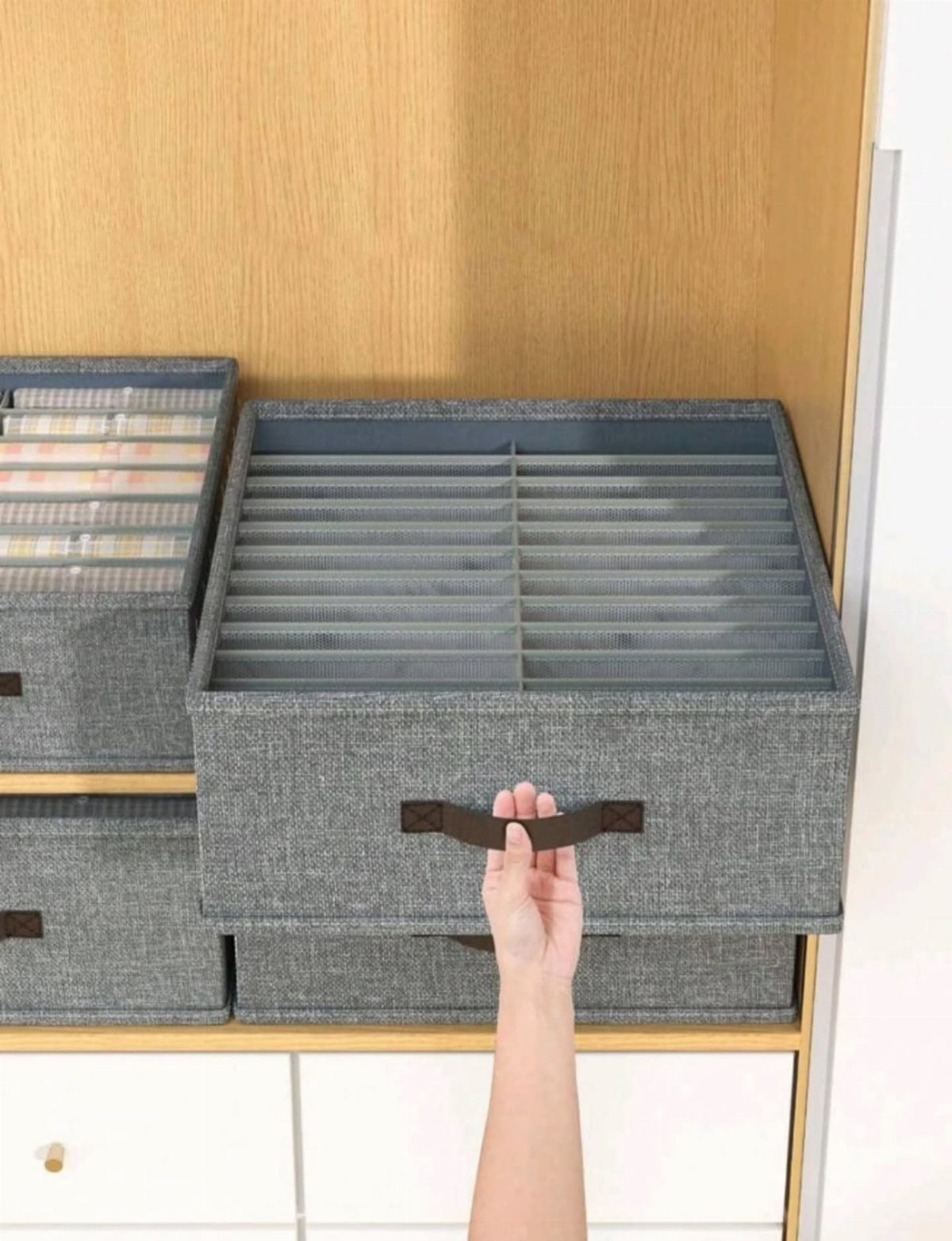 Grey fabric file box with dividers being pulled from a wooden shelf.