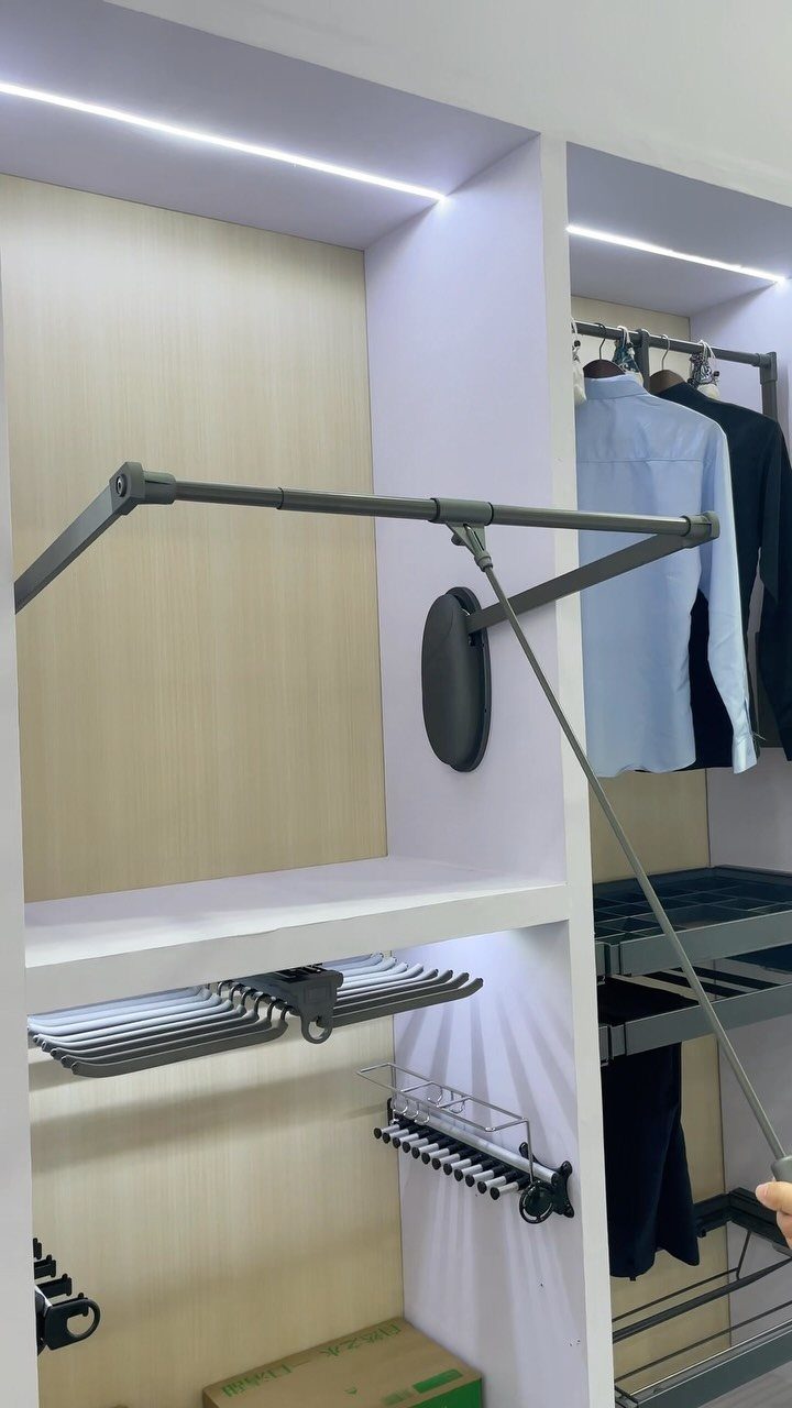 Modern white closet with pull-out hanging rod and integrated LED shelf lighting.