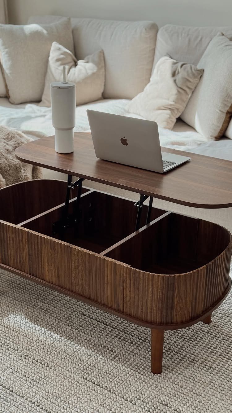 Lift-top coffee table in dark wood with open storage compartments and a laptop on top.