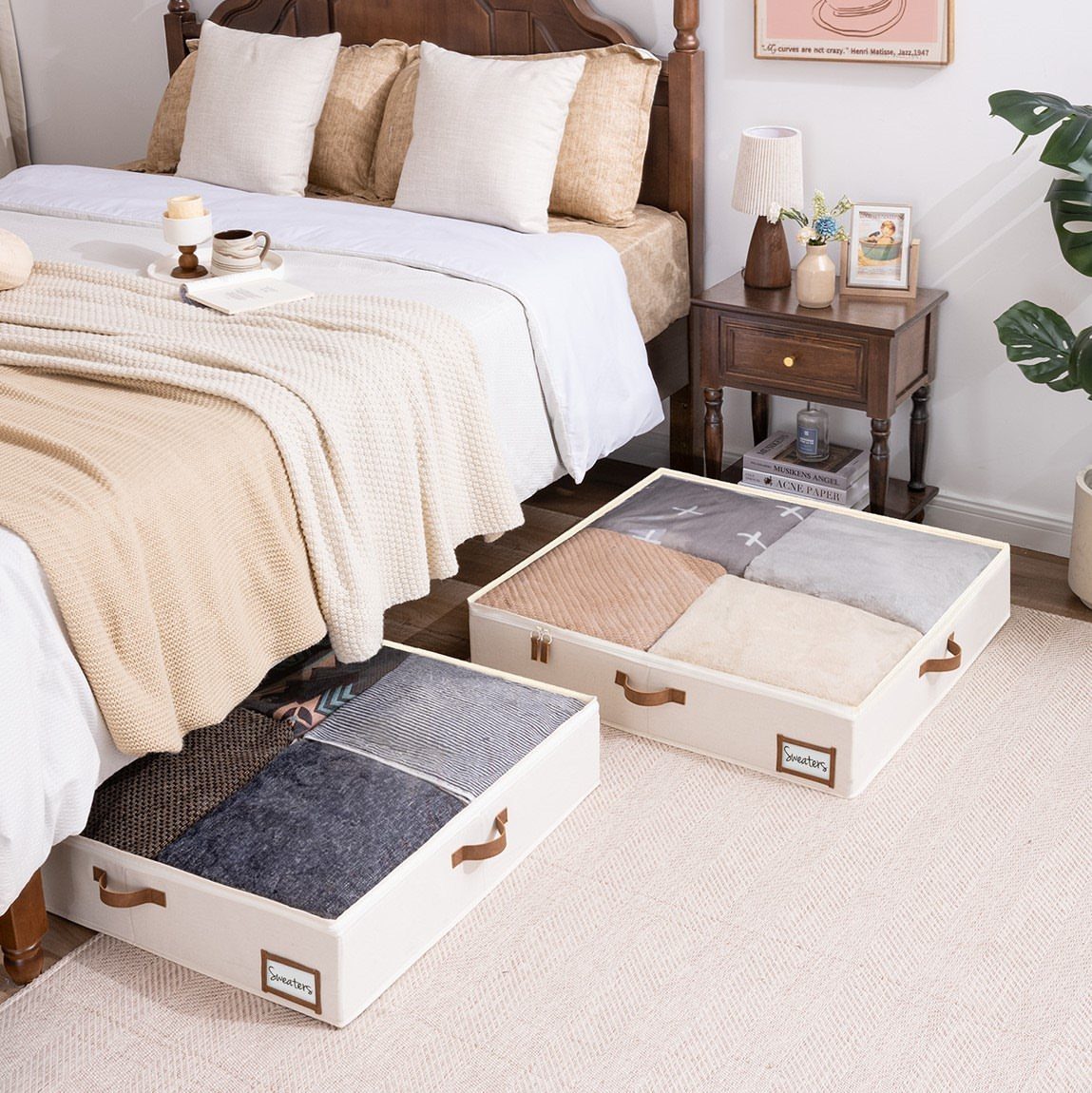 White storage bins with folded blankets pulled from under a bed.