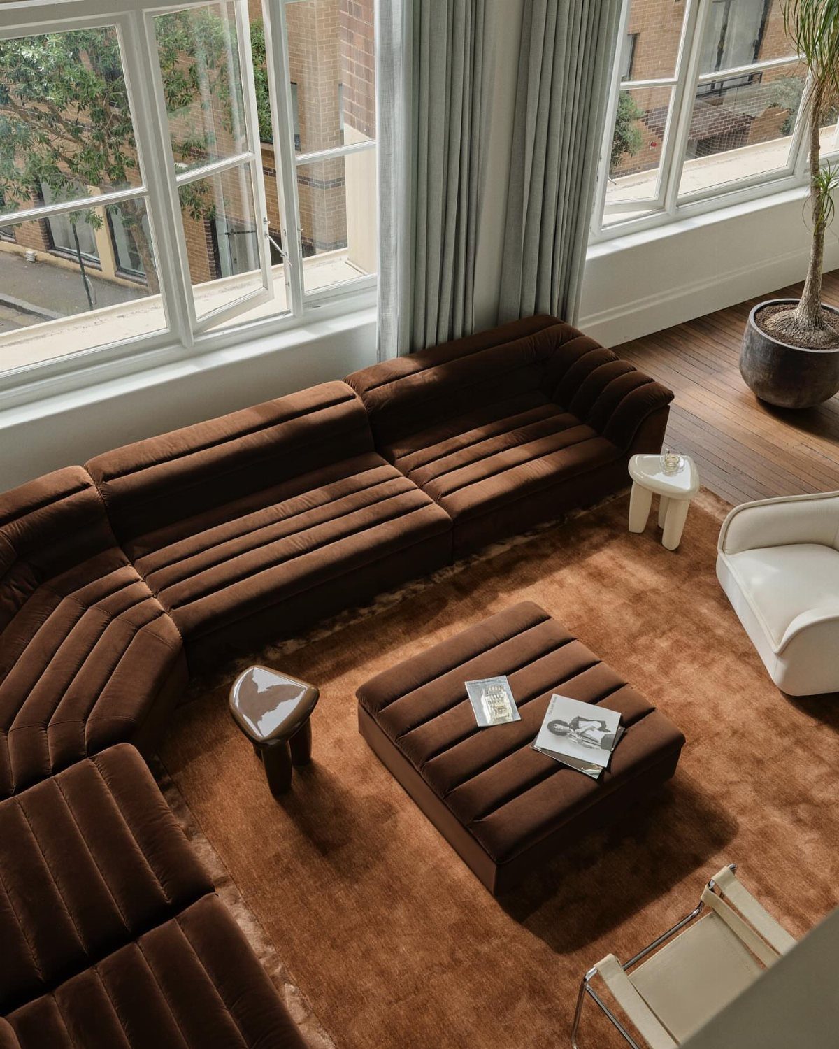 Brown ribbed sectional corner couch in a living room with a brown shag rug.
