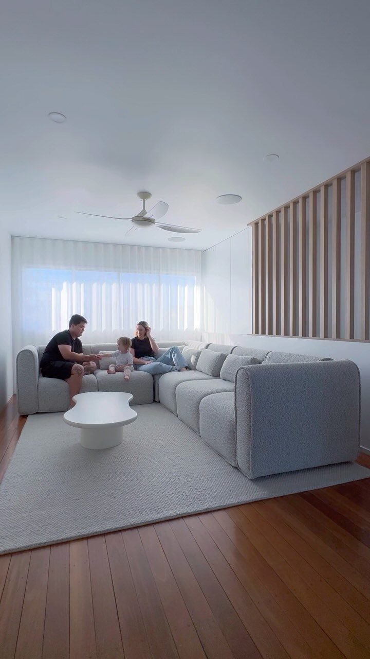 Light grey L-shaped sectional sofa with a family in a bright living room
