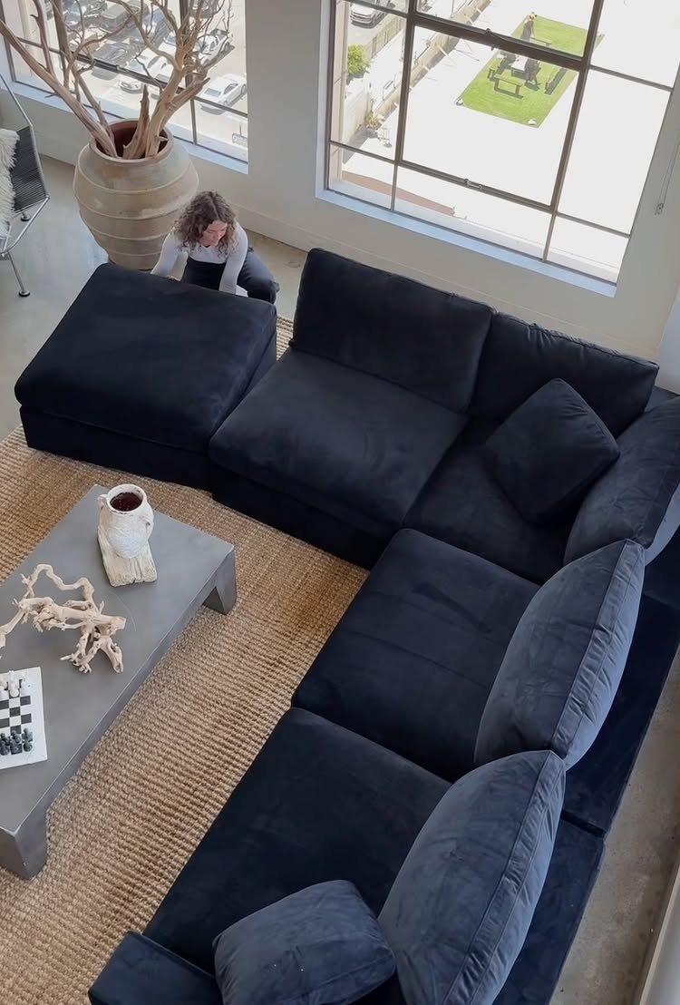 Dark navy blue modular sectional sofa in a modern living room with jute rug.