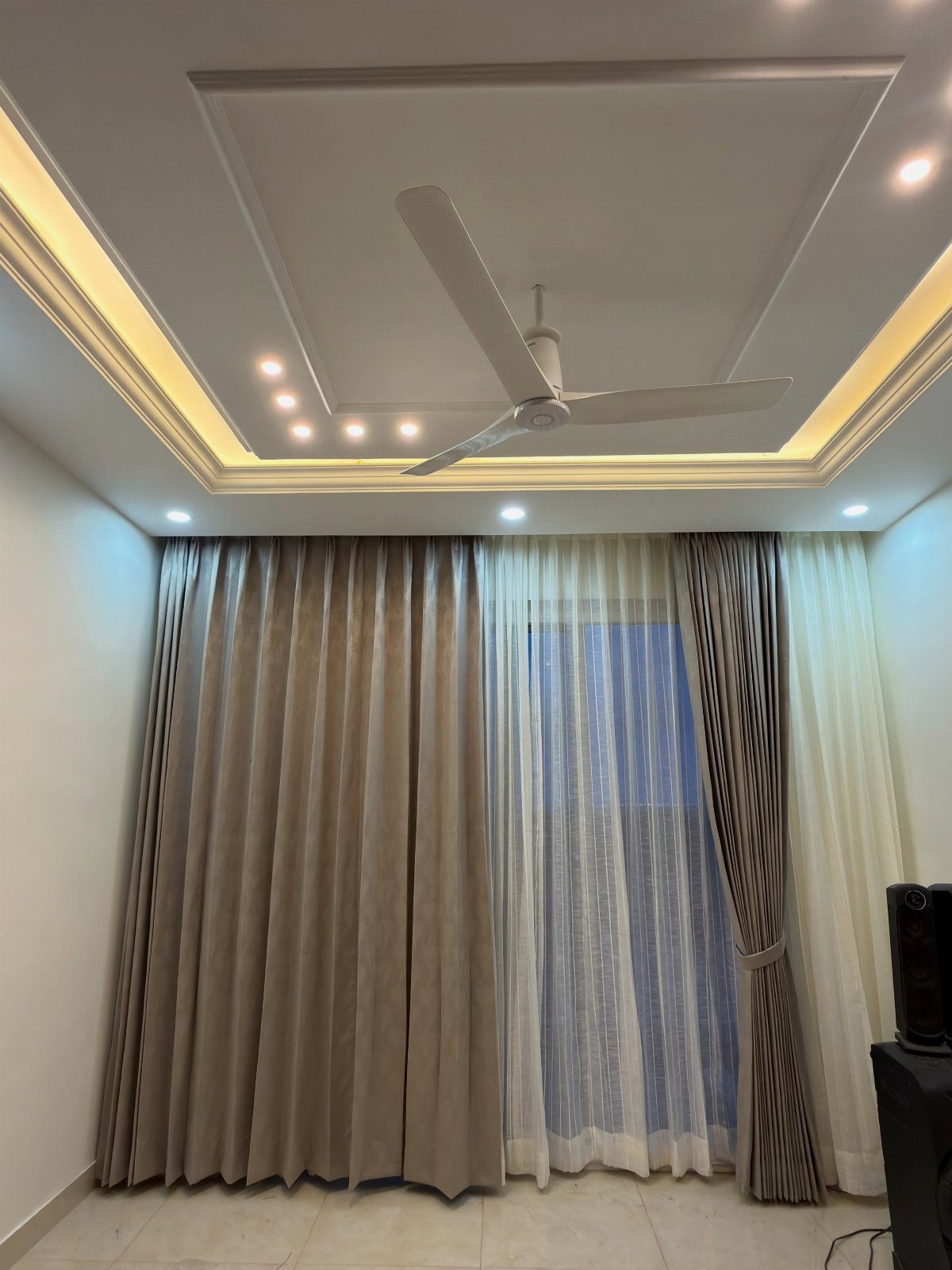 Double curtains with taupe drapes and white sheers in a modern living room.