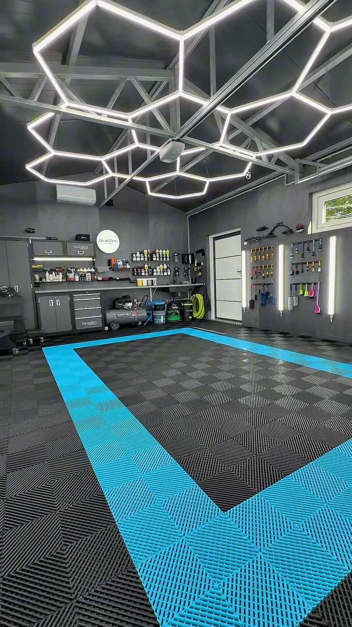 Modern garage workshop with hexagonal ceiling lights and blue and black tiled flooring.