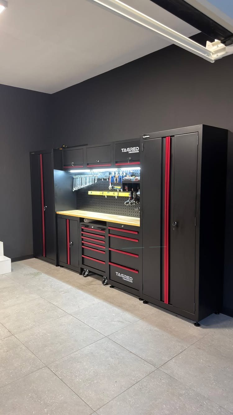 Black professional garage workshop with red accents, wooden workbench, and tool storage cabinets.