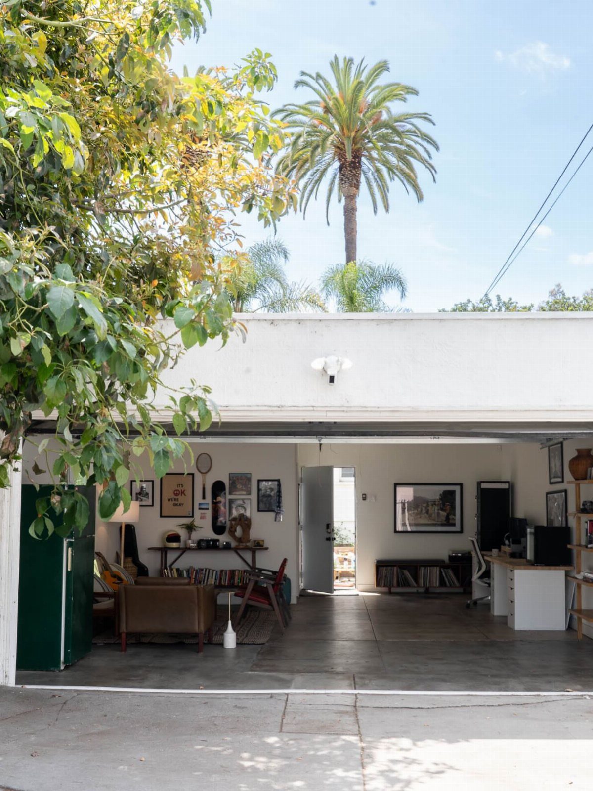 Converted garage workspace with a leather chair, desk, and white walls.