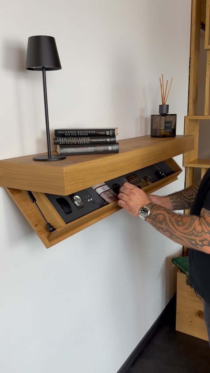 Wooden wall shelf with a hidden sliding compartment revealing a watch collection.