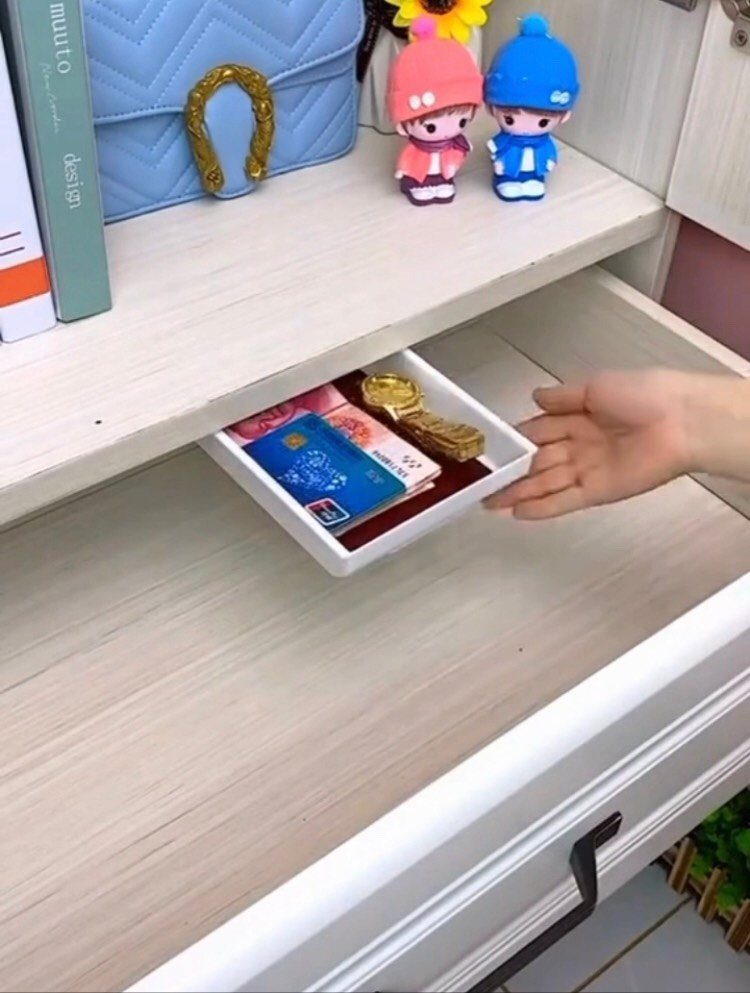 Hidden white drawer under a wooden shelf containing cards and gold jewelry.