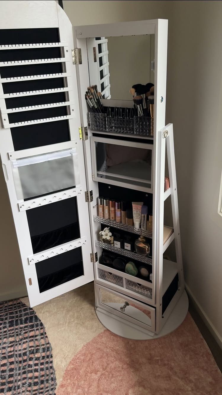 White full-length mirror cabinet open to reveal organized makeup and beauty products inside.