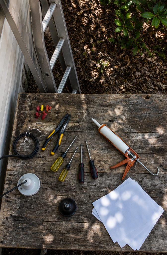 A collection of tools needed for outdoor lighting installation.