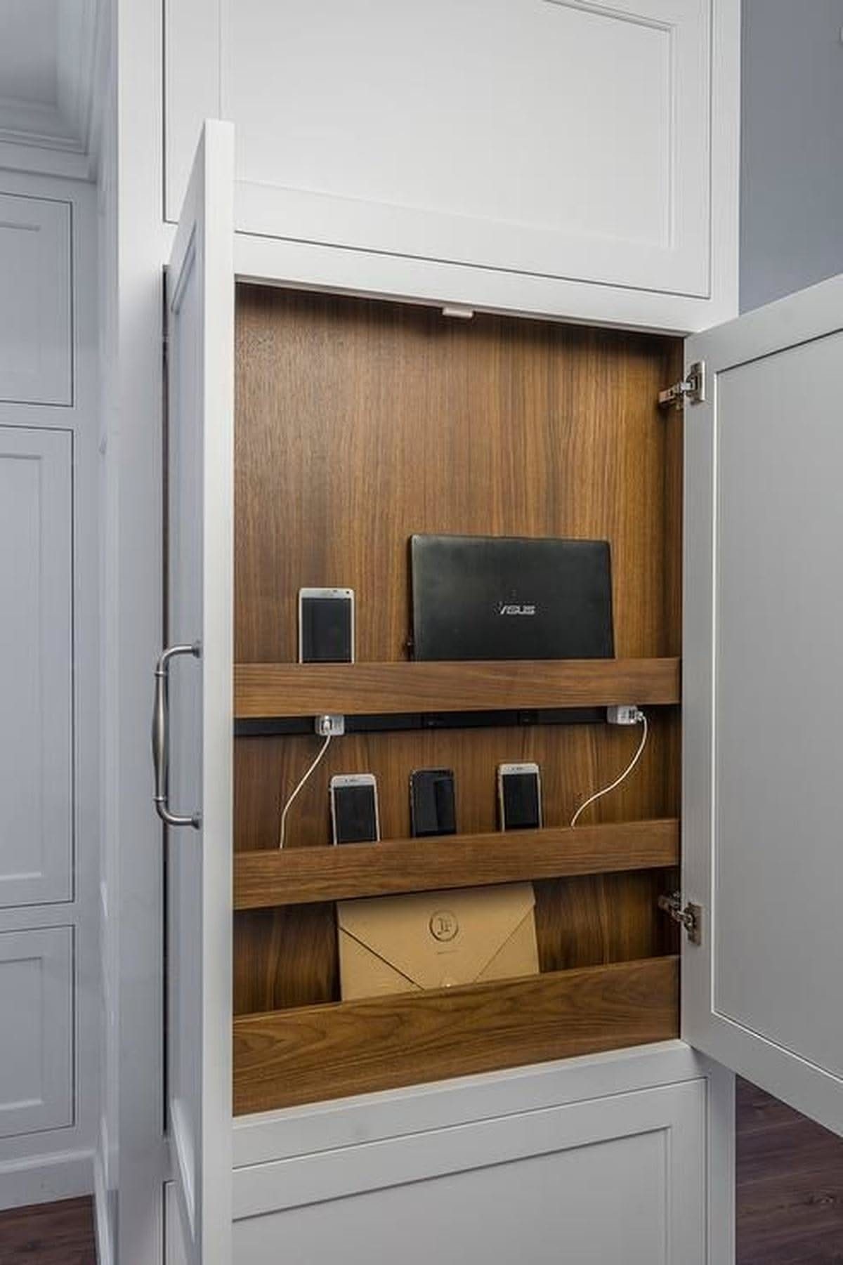 White kitchen cabinet with wood interior featuring a built-in charging station for electronics.