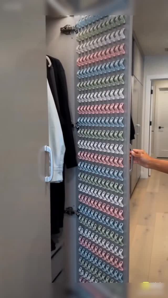 Closet door organizer with rows of colorful rolled items being opened by a hand.
