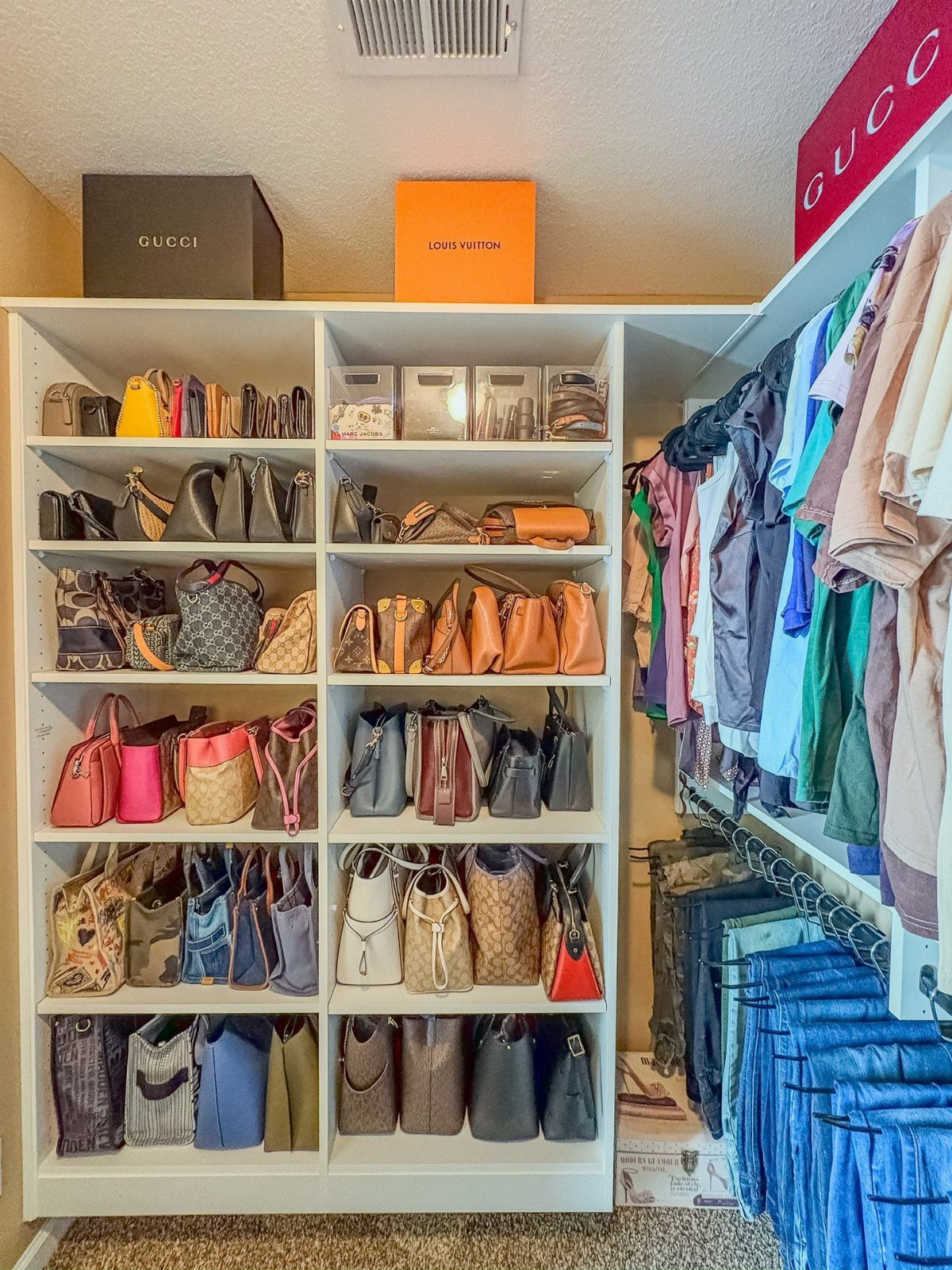 White closet shelving unit with handbags and storage boxes on the top shelf