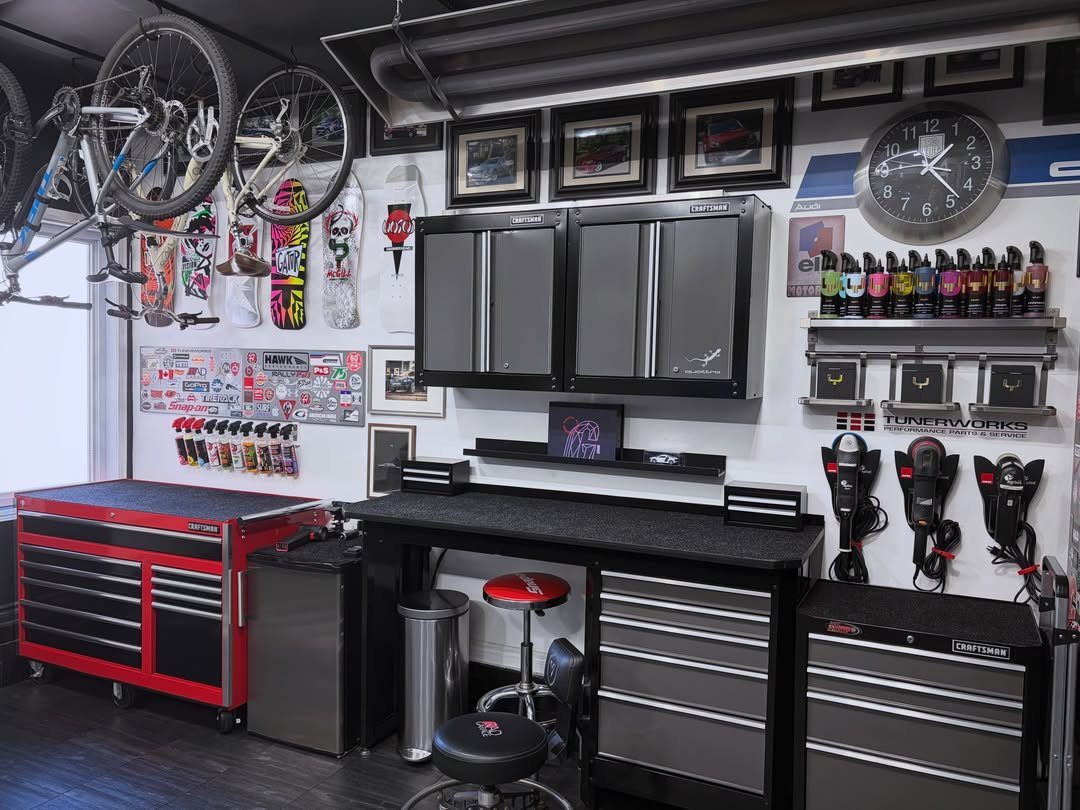 Organized garage workshop with black workbench, red tool chest, and hanging bicycles.