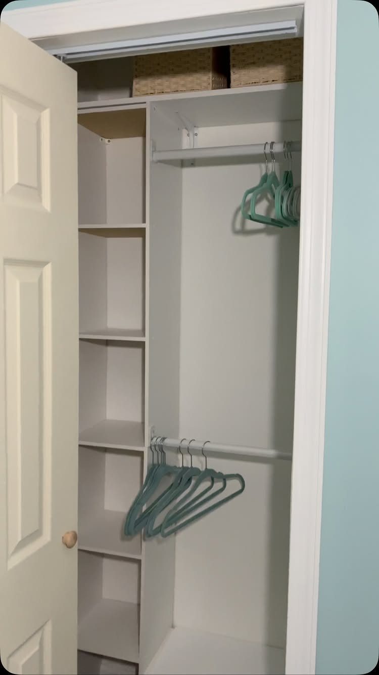 White reach-in closet with a vertical column of cubby shelves and hanging rods.