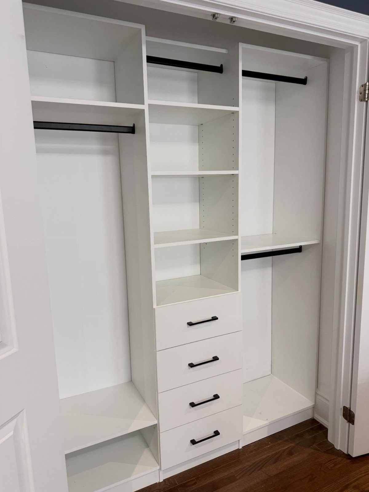 White reach-in closet system featuring double-hang rods, shelving, and four storage drawers.