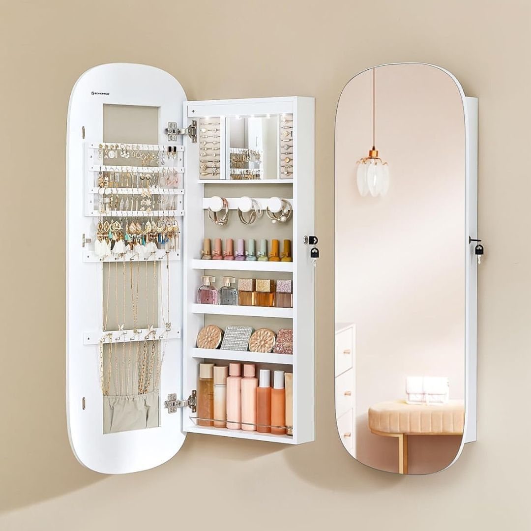 White wall-mounted jewelry cabinet with an open door showing organized accessories and cosmetics.