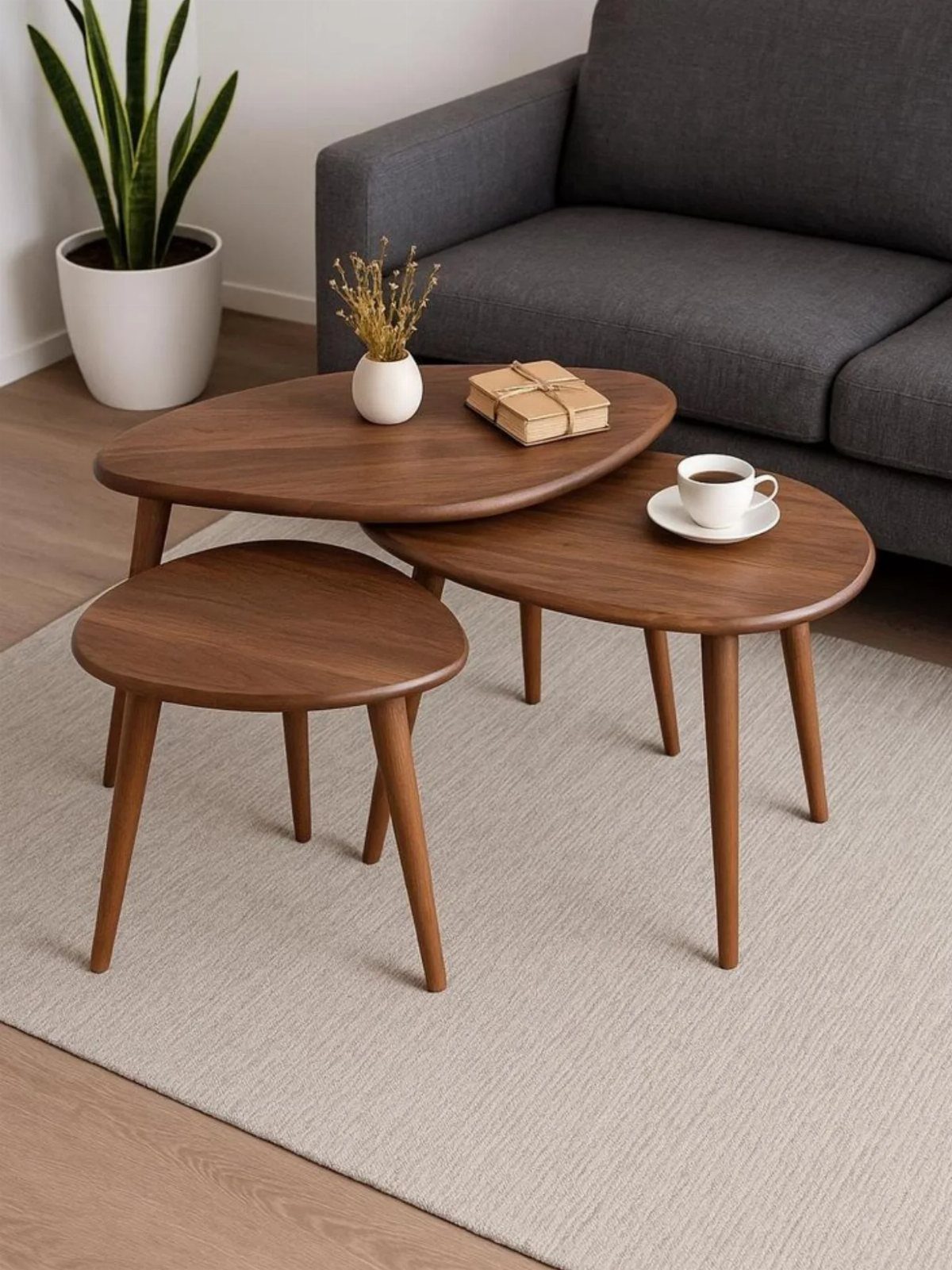 Three walnut nesting coffee tables of different sizes in a modern living room.