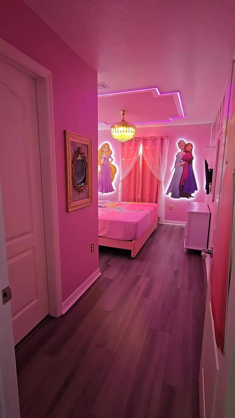 Pink toddler girl's bedroom with princess wall decals and a gold chandelier