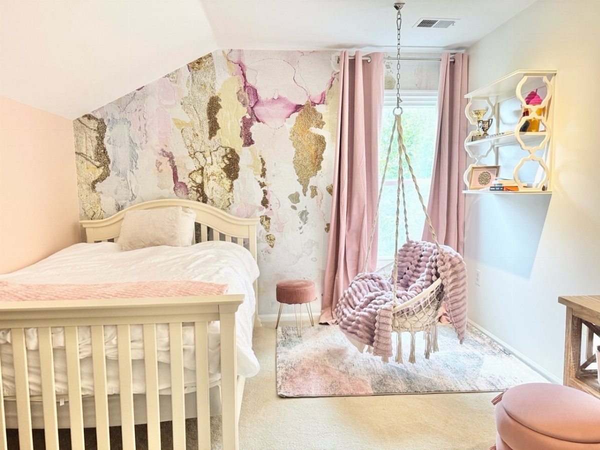 Toddler bedroom with a gold and pink marble wall mural and hanging swing chair