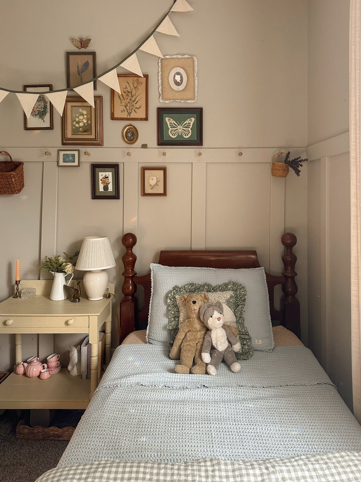 Beige toddler bedroom with wainscoting, a small bed, and botanical wall art.