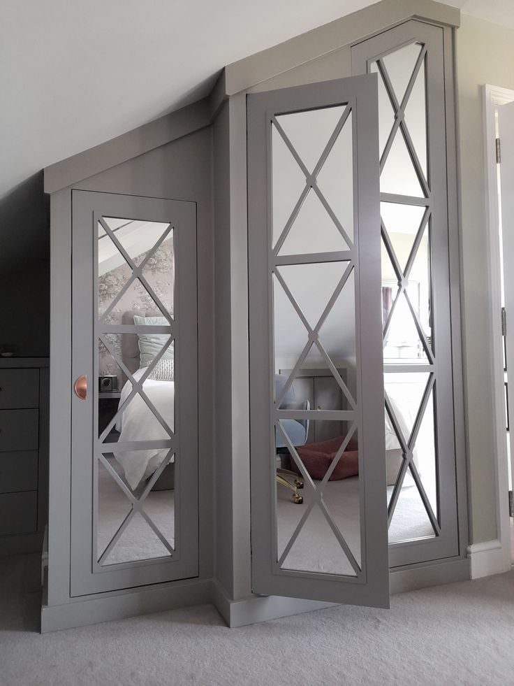 Grey under stair storage cabinets with mirrored doors and criss-cross lattice detailing.