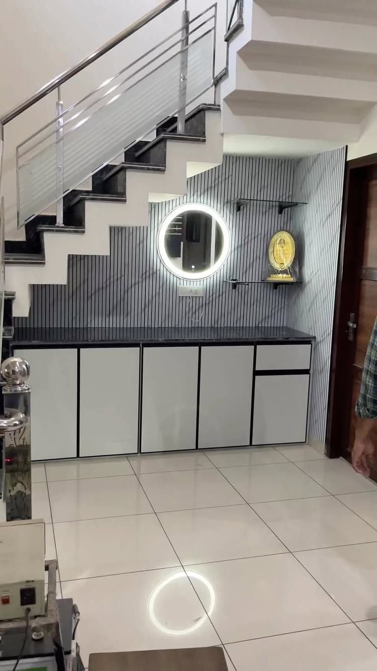 White under stair storage cabinets with a round backlit mirror on a striped wall.