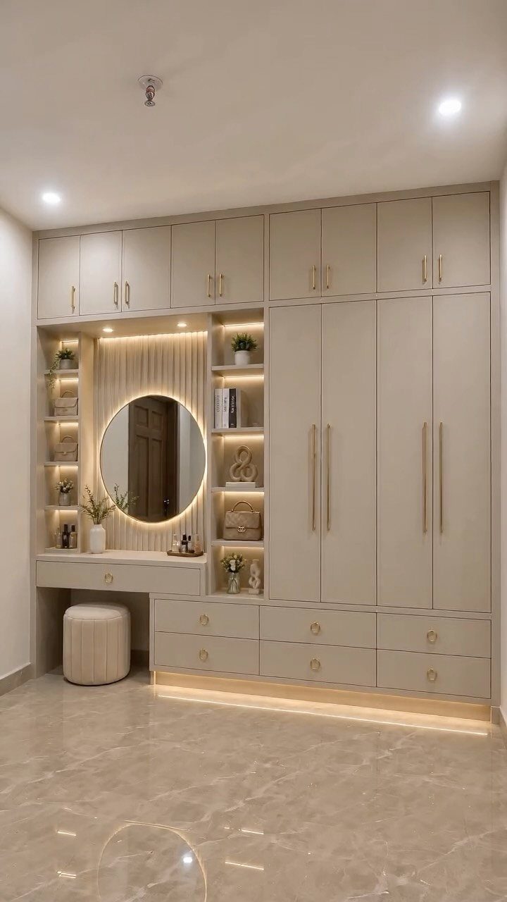 Beige built-in wardrobe with integrated vanity, round mirror, and multiple storage cabinets.