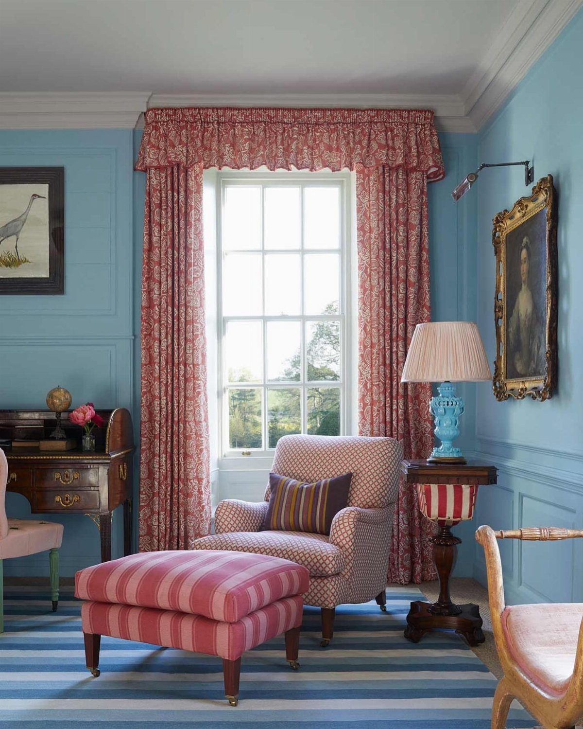 Red floral window curtains with a matching valance in a blue living room.